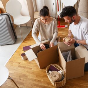 Couple packing boxes for move